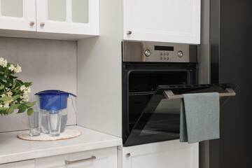 Fototapeta premium Open electric oven with towel in kitchen. Cooking appliance
