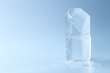 Blocks of clear ice on light blue background, space for text