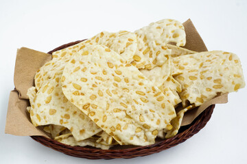 keripik tempe or tempeh chips are made from soybeans and served on a rattan basket