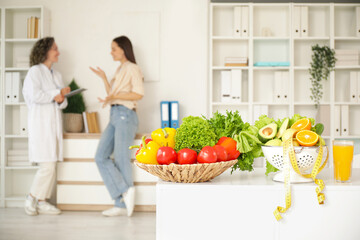 Healthy food with tape measure on table in nutritionist's office, closeup