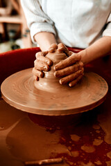 Hands, pottery wheel and woman with clay, artist and creativity in workshop, productivity and tools. Closeup, entrepreneur and person with equipment, designer and hobby with small business or talent