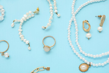 Beautiful pearl jewelry on blue background. Top view