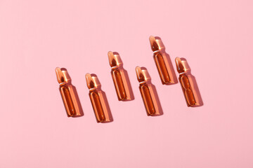 Glass ampules on pink background
