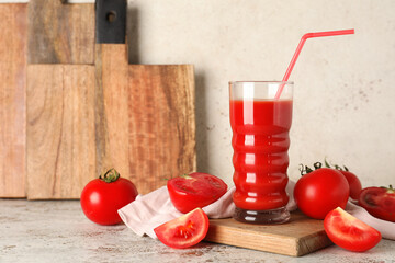 Glass of fresh tomato juice and vegetables on white background