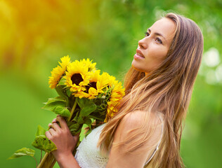 Nature, woman and holding bouquet of sunflowers with thinking, summer and ideas for eco gift. Female person, relax and flowers in park with contemplating for floral present, spring and sustainability