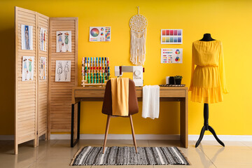 Interior of atelier with tailor's workplace, mannequin and folding screen