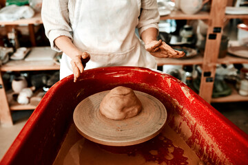 Hands, clay and pottery wheel for molding art in workshop, woman and creative craftsmanship. Female person, fingers and artist for skilled design in studio, sculpting and tool for handmade culture