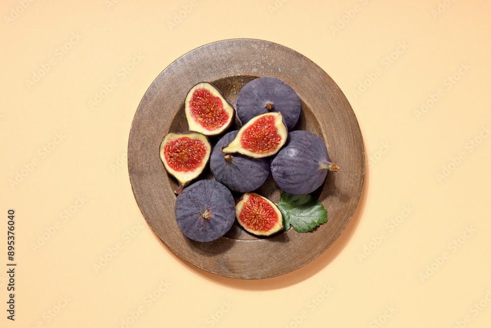 Wall mural Fresh ripe figs in a wooden bowl on a light background