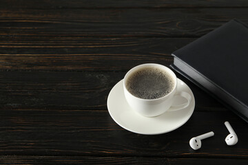 A cup of coffee with headphones on a dark background