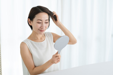 ヘアケアをする若い女性　ビューティーイメージ