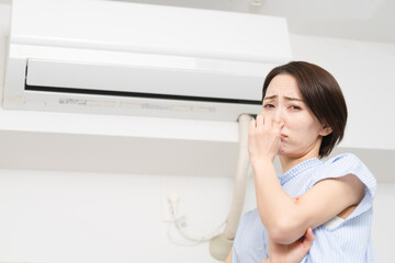 エアコンの匂いが気になる若い女性　ライフスタイルイメージ	