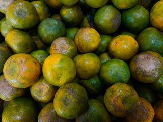 Stacks of orange fruits that look very fresh with a tasteful color at market outdoor