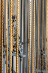 Vertical Image.  Theater stage rigging with theatrical equipment, lighting, supports, and chains. Photo taken from an elevated position looking across the rigging.	