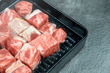 A tray of meat is on a counter