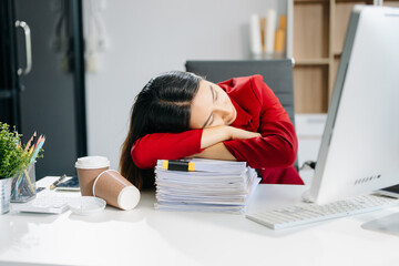 Overworked young Asian businesswoman office worker suffering from neck pain after had a long day at her office