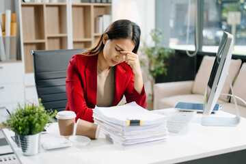 Overworked young Asian businesswoman office worker suffering from neck pain after had a long day at her office