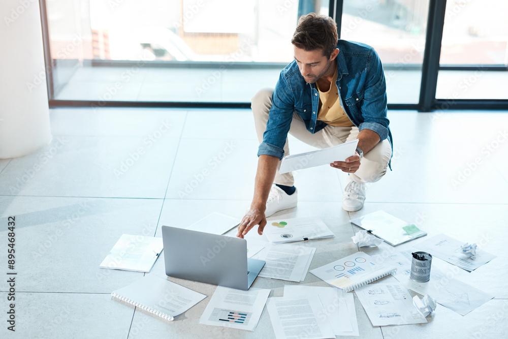 Poster man, laptop and paperwork on floor in office for research, information and brainstorming solution of