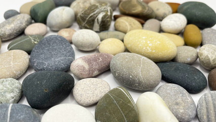 Sea stones on a white background. Lots of sea pebbles
