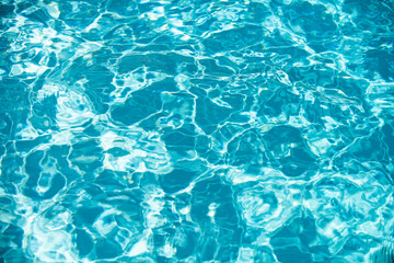 Ripple Water in swimming pool with sun reflection. Wavy water background.