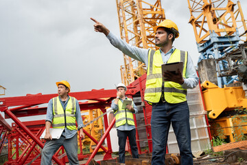 India engineer man worker use tablet computer and finger point with team and spare crane background 