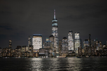 Fototapeta premium Night in The NYC city, USA, United States. Night day with iconic buildings. New York City NYC Manhattan Downtown Skyline, viewed from Jersey City, USA.