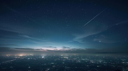 Fototapeta premium A shooting star streaks across a starry night sky over a distant cityscape.