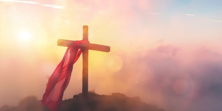 Wooden cross with red cloth in misty sunlight