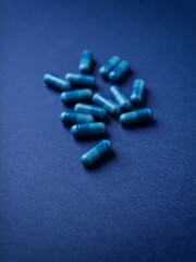 Amino acids capsules on dark paper background. Soft focus.	