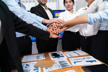Multiracial business people make synergy hand stack together in meeting room as cooperation or team building for corporate employee in workplace. Meticulous