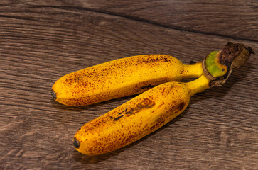 Baby bananas with black dots lie on the table