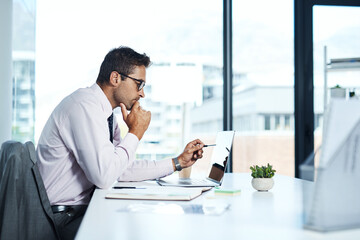 Accounting, laptop and review with financial advisor man at desk in office for decision or planning. Computer, reading and thinking with accountant or bookkeeper in workplace for portfolio management