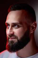Obraz premium Studio portrait with colorful light of young handsome bearded man.