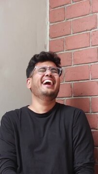 a man is laughing out loud. he is unable to control the laughter, he is extremely thrilled and laughing cats and dogs. intense laughter helps the immune system. Indian male in happy mood and enjoying 