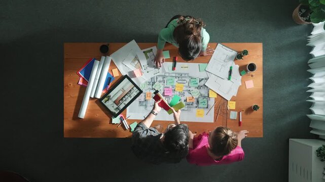 Time lapse of engineer working together to design building construction while standing at meeting table with blueprint and notes. Top view of interior designer choosing color from palettes. Symposium.