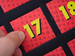 A woman hand ready to open the door with number 17 on the advent calendar.