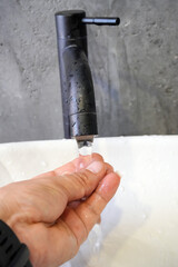 Wash your hands in the sink with one hand.