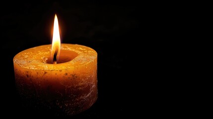 a single candle burning on a black background