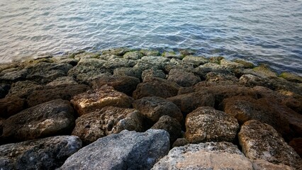 an arrangement of stones dividing the beach and sea to break the waves.