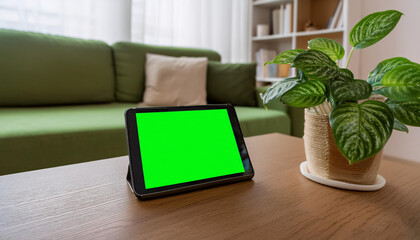 Fototapeta premium A digital tablet with a green screen placed on a conference table during a business meeting, perfect for showcasing presentations or business applications.