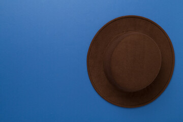 Brown autumn hat on color background, top view