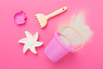 Cute toys for playing with sand on color background, top view