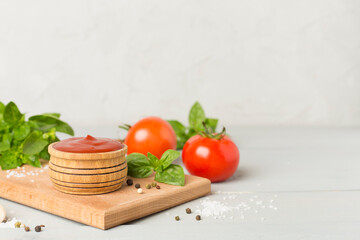 Delicious ketchup with spices and tomatoes on wooden table