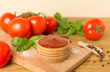 Delicious ketchup with spices and tomatoes on wooden table
