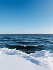 Obraz premium An ocean winter scene with a clear sky captures the serene beauty of the sea during the colder months. 