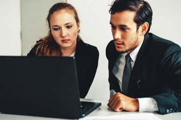 Obraz premium Unhappy serious businessman and businesswoman working using laptop computer on the office desk. Bad business crisis situation and bankruptcy concept. uds