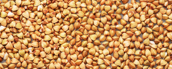 Naklejka premium Hulled kernels of buckwheat cereal isolated on white background.