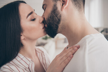 Photo of attractive trendy cheerful married young couple kissing lips spending free time move new apartment home interior indoors