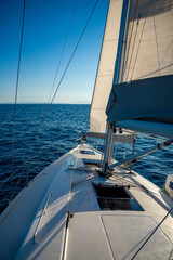 Yacht sailing in an open sea. Close-up view of the deck, mast and sails. Yachting concept