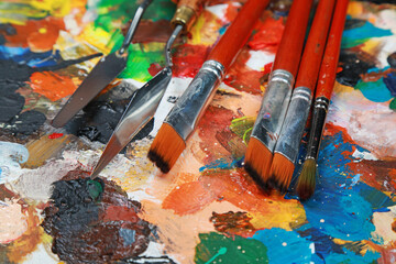 Palette with paints and canvases.	
