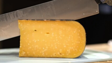  Close-up of hand cutting large pieces of French cheese.Cutting Cheese Slices. Organic food Concept. Milk Product. Ecological Farming. 4K footage